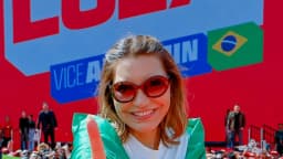 Apoiadora grava com o celular o lançamento da campanha de reeleição de Lula, com telão e multidão ao fundo