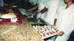Cozinheiros preparam e servem pratos em restaurante