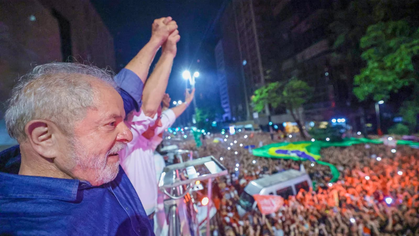 Lula acena com o punho erguido para multidão durante discurso, em foto de arquivo
