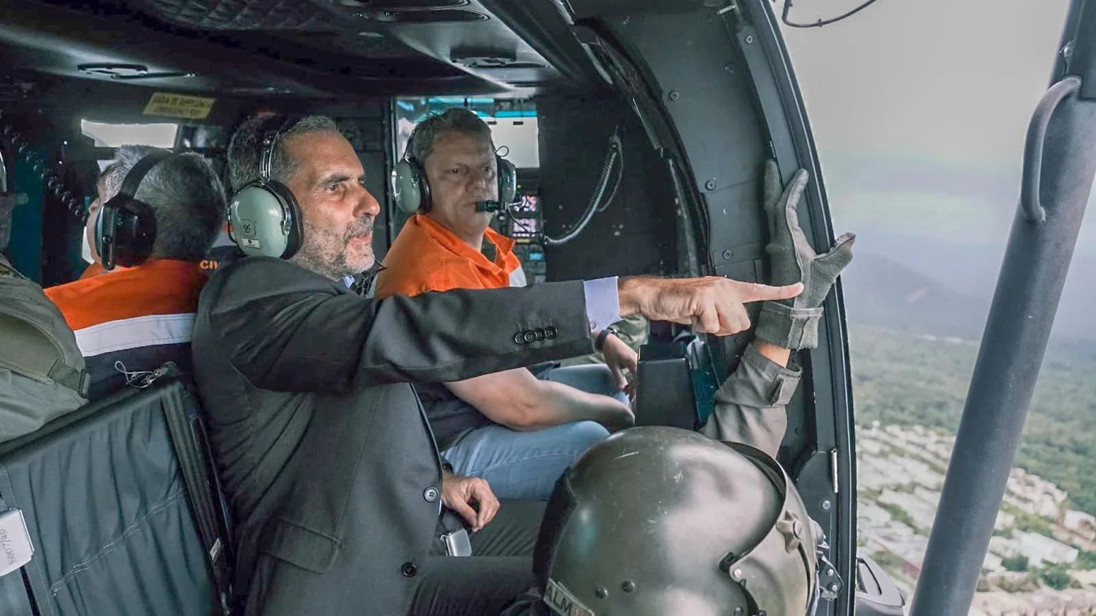 O governador Tarcísio de Freitas observa área sobrevoada de helicóptero, ao lado de auxiliares (foto de arquivo)