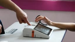 Mãos de um eleitor votando em urna eletrônica