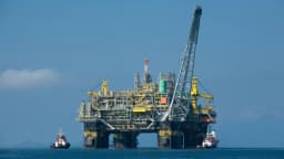 Plataforma de petróleo P-51 da Petrobras no mar, com rebocadores ao redor
