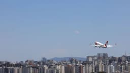 Avião executivo decola sobre área urbana, imagem de arquivo sobre aviação executiva