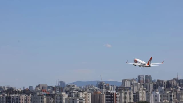 Avião executivo decola sobre área urbana, imagem de arquivo sobre aviação executiva