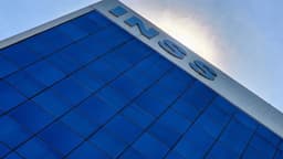 Fachada do prédio-sede do INSS em Brasília, vista de baixo para cima, com o letreiro da instituição contra o céu azul