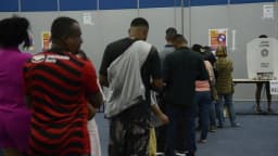 Eleitores em fila para votar em seção eleitoral no 1º turno das eleições 2026