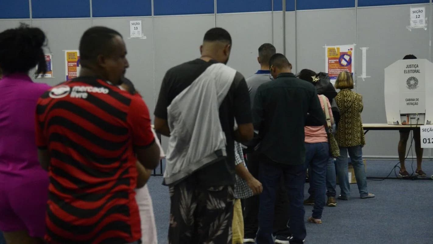 Eleitores em fila para votar em seção eleitoral no 1º turno das eleições 2026