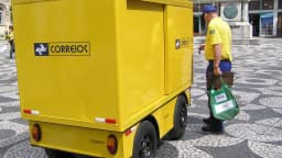 Carteiro ao lado de veículo dos Correios em Curitiba, em janeiro de 2006; foto de arquivo.
