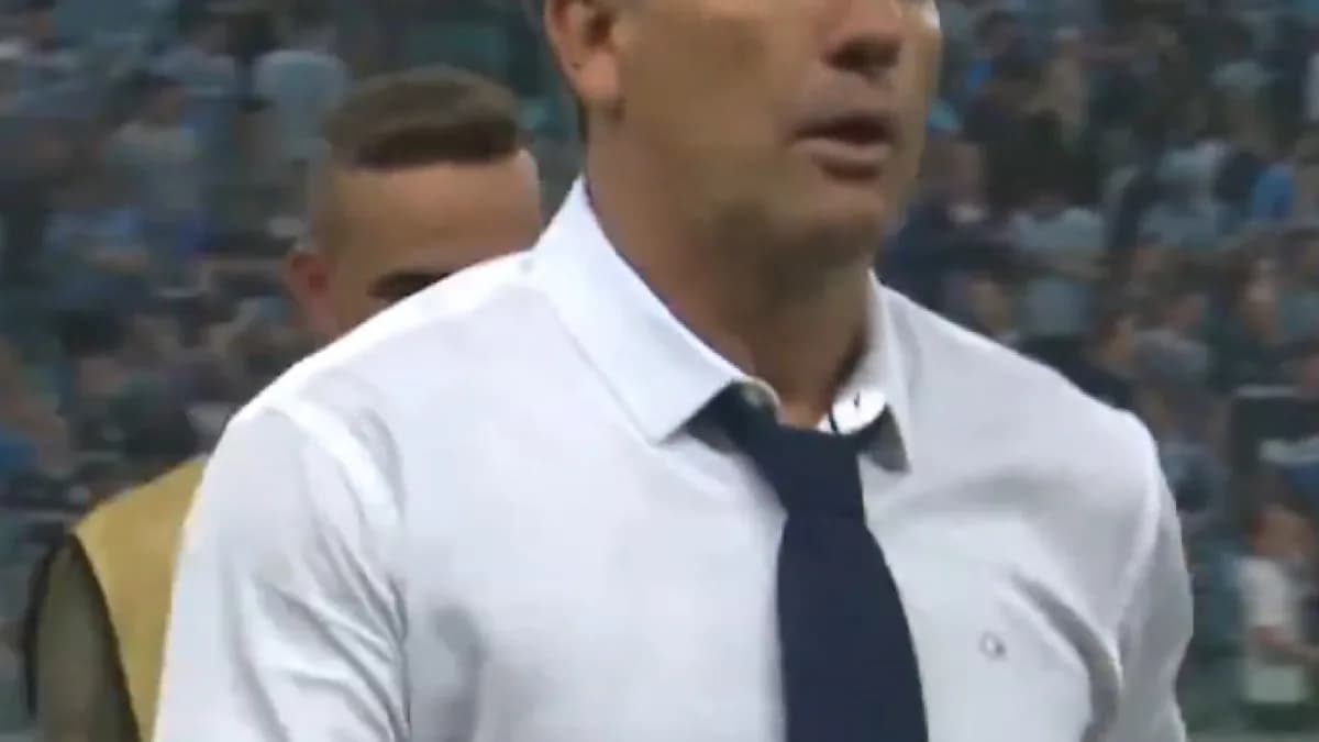 Renato Gaúcho à beira do gramado da Arena do Grêmio, de terno branco e gravata, em jogo do clube