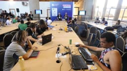 Desenvolvedores trabalhando em computadores durante hackathon