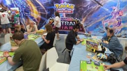 Pessoas jogando e trocando cartas do jogo Pokémon Trading Card Game em evento