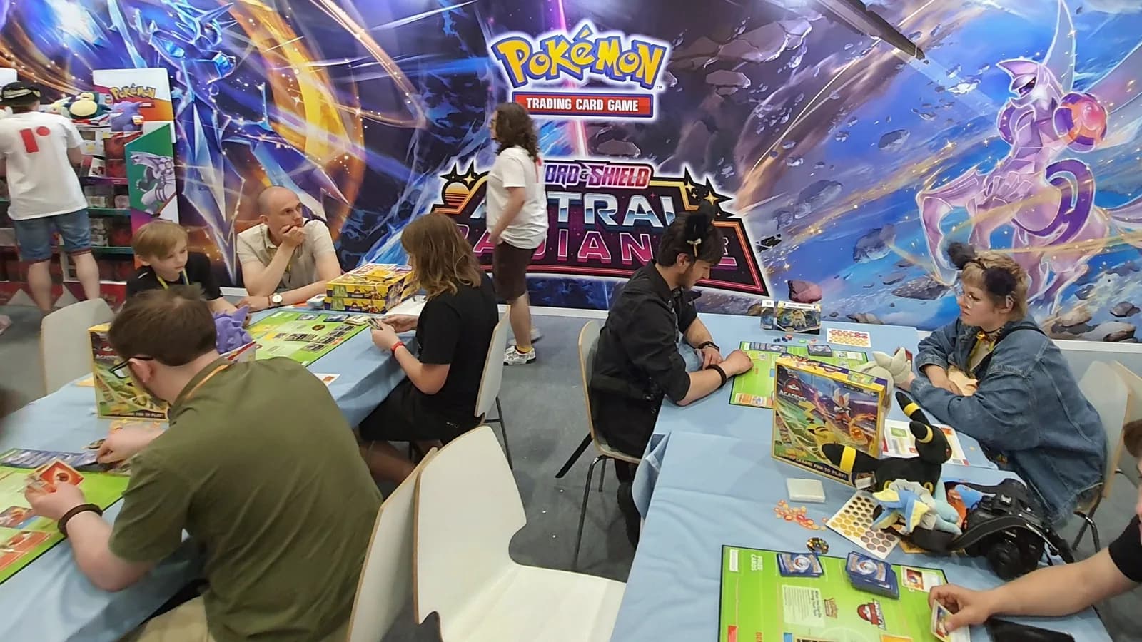 Pessoas jogando e trocando cartas do jogo Pokémon Trading Card Game em evento
