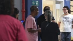 Eleitores conversam em fila de votação durante o primeiro turno de 2026