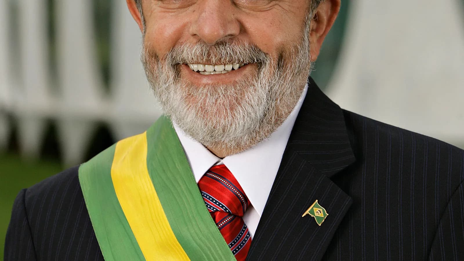 Lula em retrato oficial, sorrindo, usando a faixa presidencial