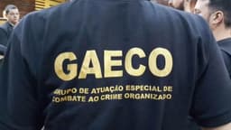 Policial com a camisa do GAECO (Grupo de Atuação Especial de Combate ao Crime Organizado) estampada nas costas, durante ação institucional