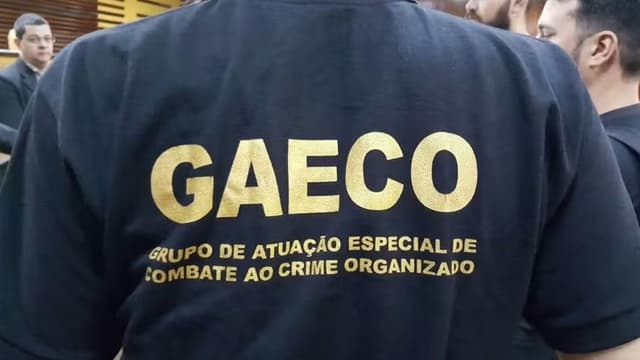Policial com a camisa do GAECO (Grupo de Atuação Especial de Combate ao Crime Organizado) estampada nas costas, durante ação institucional