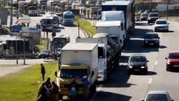 Fila de caminhões e caminhoneiros parados às margens de uma rodovia, imagem de arquivo