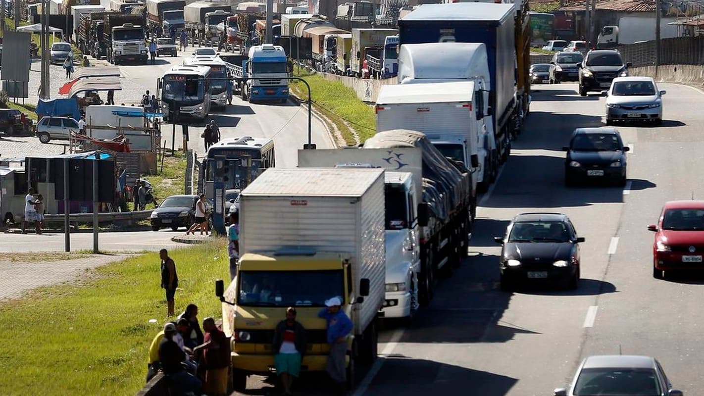 Fila de caminhões e caminhoneiros parados às margens de uma rodovia, imagem de arquivo