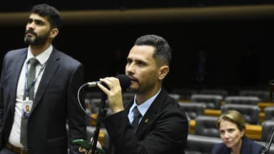 Parlamentar discursa ao microfone no plenário, com fileiras de cadeiras vazias ao fundo, durante sessão conjunta do Congresso Nacional; imagem de arquivo