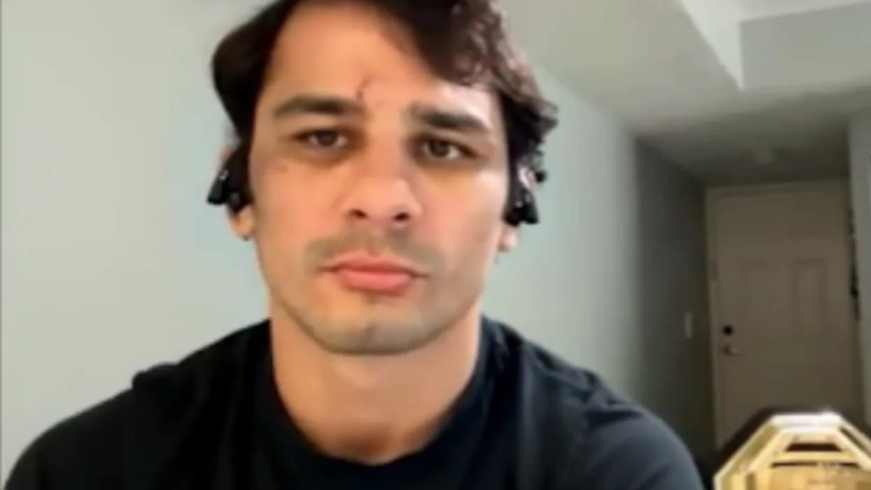 Alexandre Pantoja durante entrevista, com o cinturão dos moscas visível ao fundo