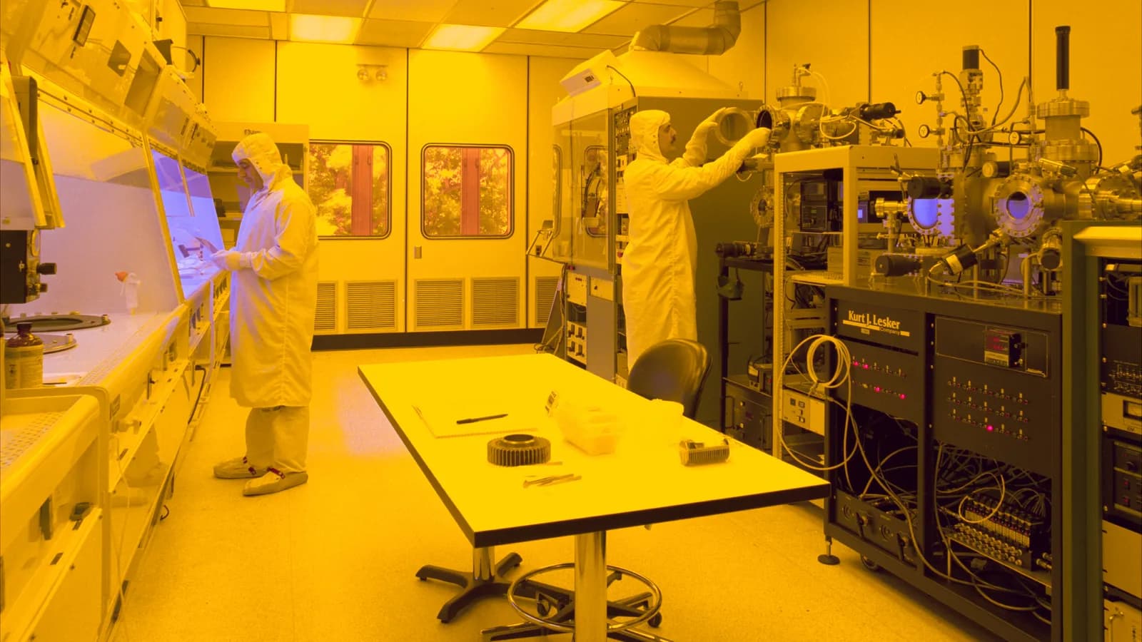 Técnicos trabalham em sala limpa de fábrica de semicondutores