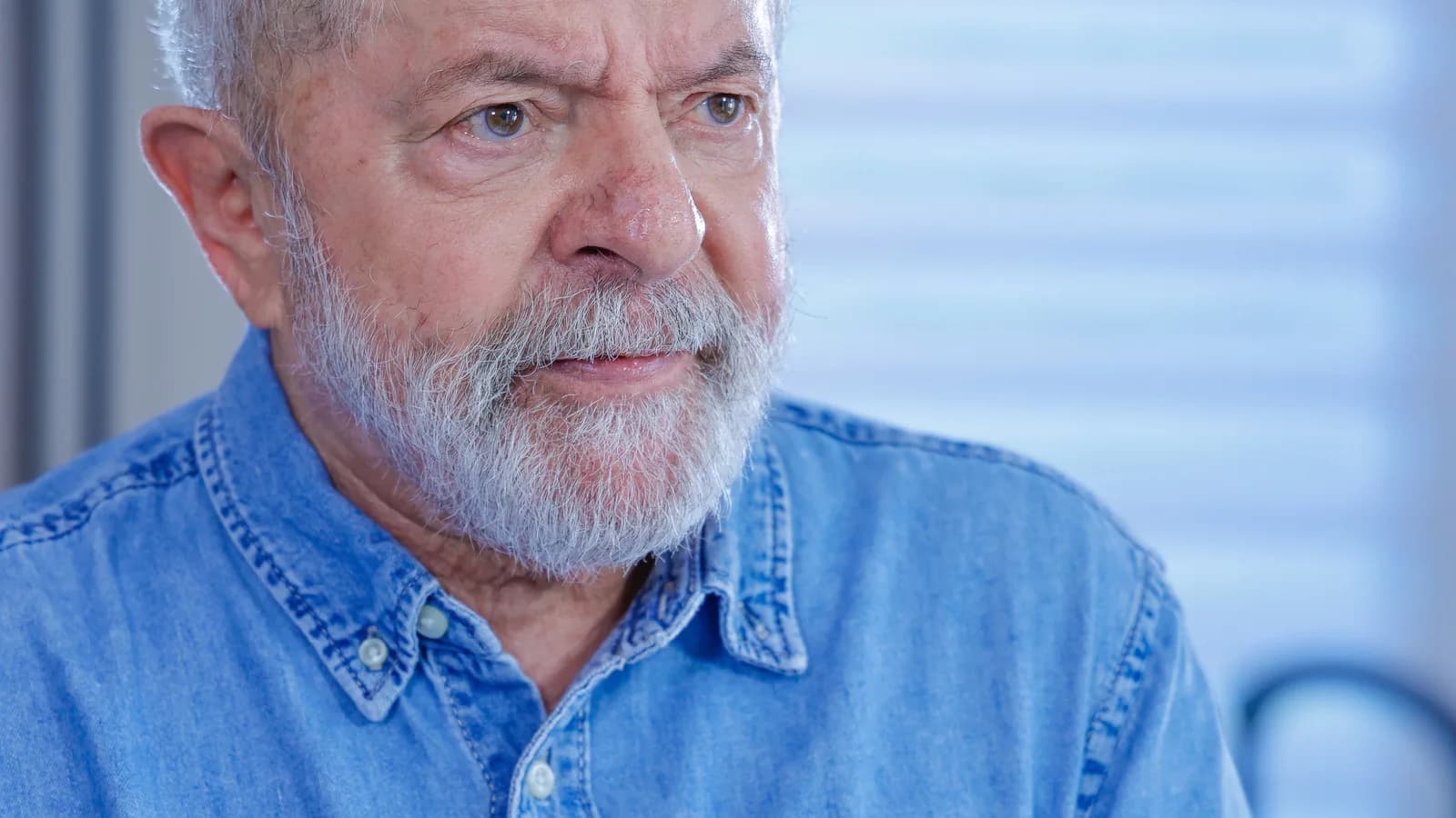 Lula em entrevista, usando camisa jeans, gesticulando enquanto fala