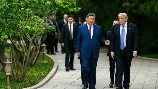Xi Jinping e Donald Trump caminham lado a lado durante encontro diplomático.