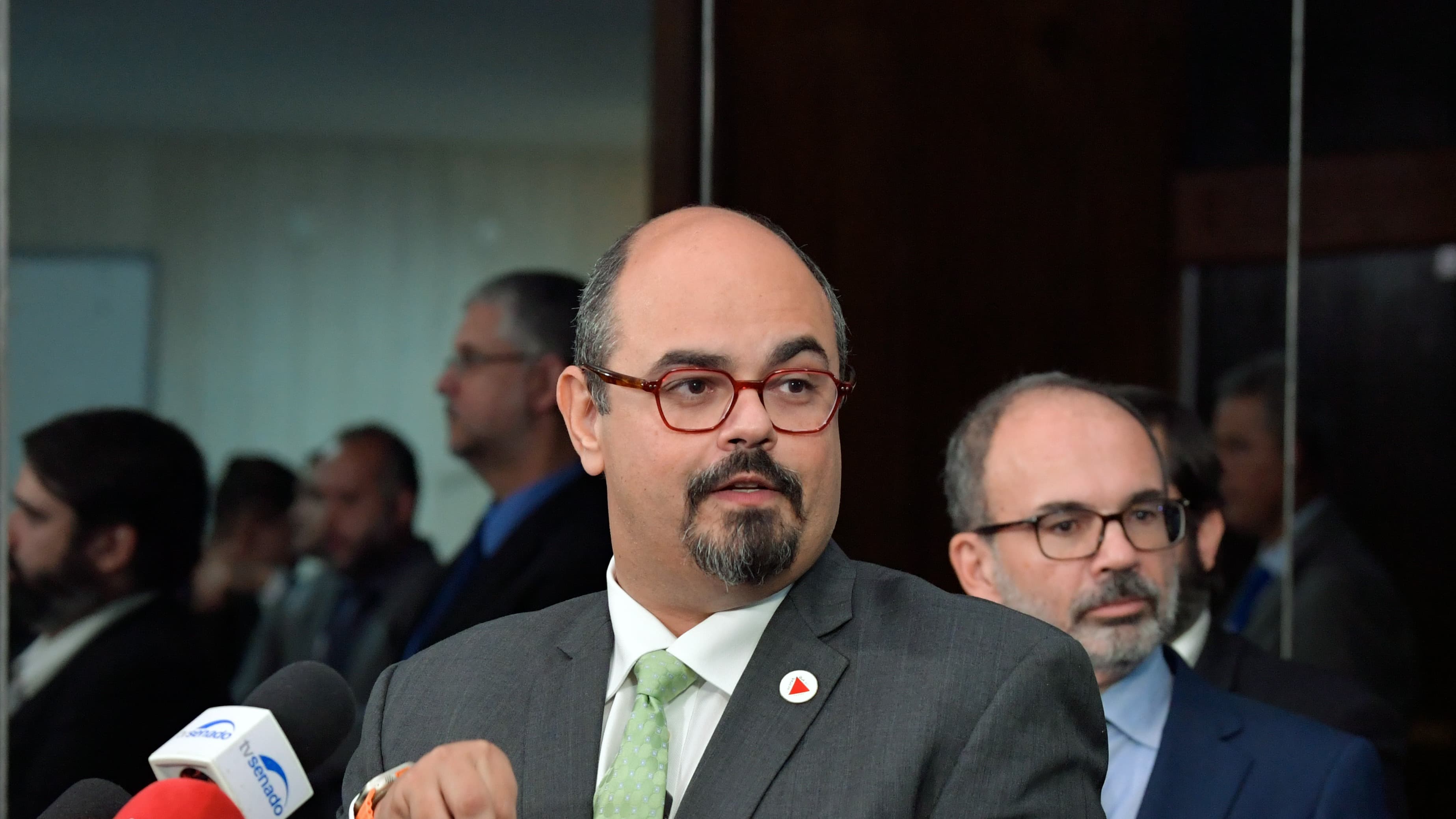 Mateus Simões, candidato ao governo de Minas Gerais, fala em coletiva de imprensa cercado de microfones