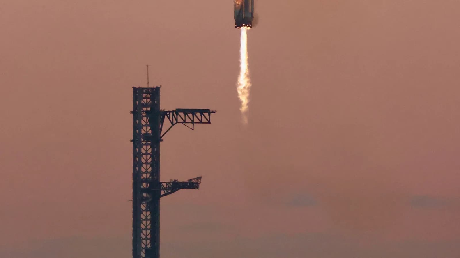 Foguete Starship da SpaceX em pleno voo com chamas do propulsor