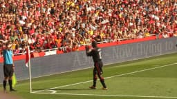 Clarence Seedorf em campo, vestindo uniforme do Milan, durante lance de jogo com torcida ao fundo