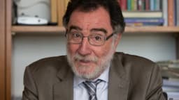 Patrus Ananias, candidato do PT ao governo de Minas Gerais, em entrevista de terno em escritório com estante de livros ao fundo