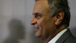 Aécio Neves, de perfil, em ambiente formal