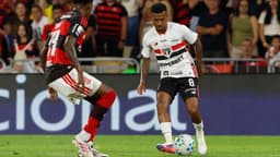Jogador do São Paulo conduz a bola marcado por jogador do Flamengo durante partida no Maracanã