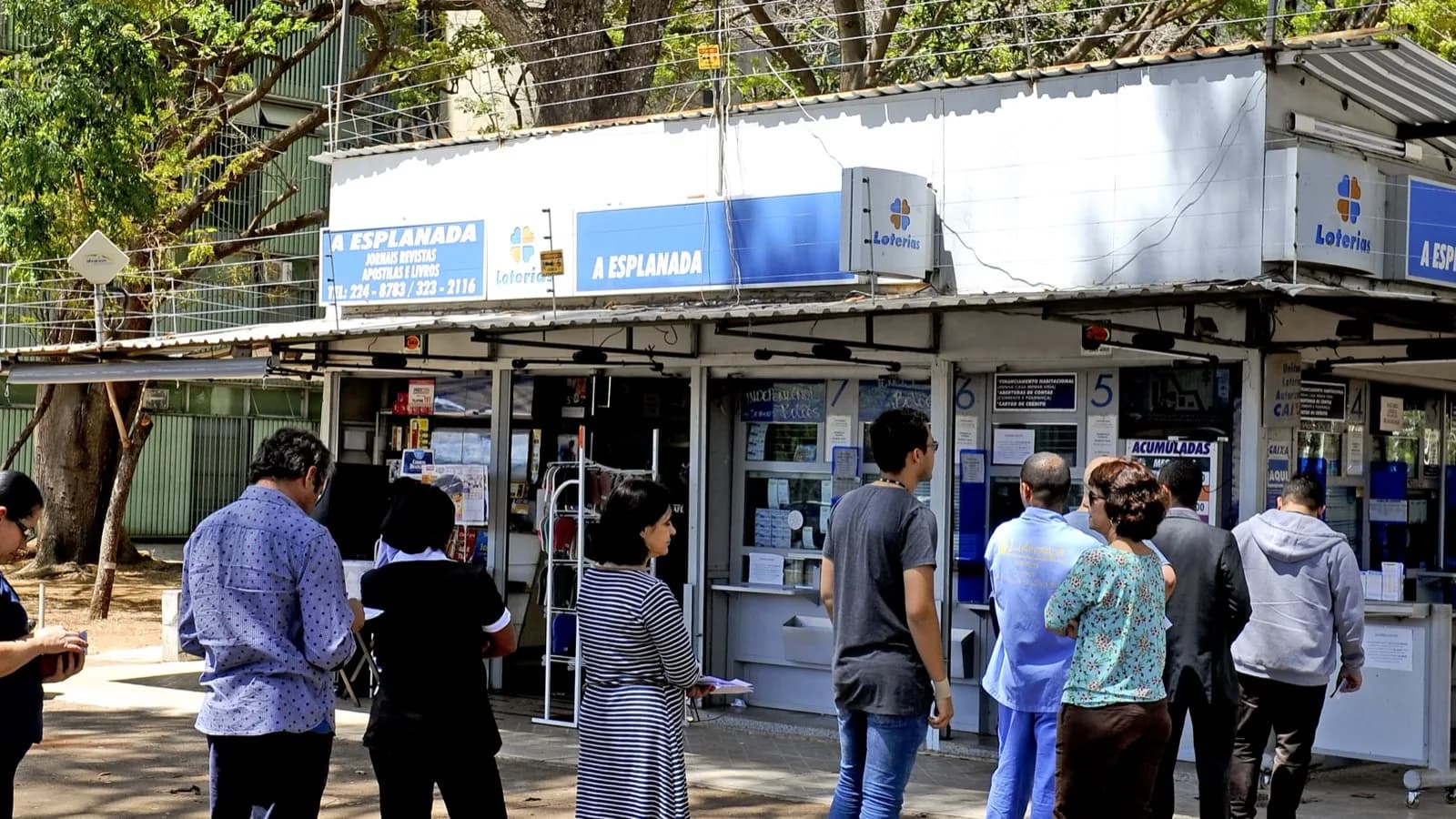 Fila de pessoas em frente a uma casa lotérica para apostar