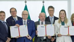 Lula sorri ao lado de autoridades durante cerimônia de sanção de leis no Palácio do Planalto
