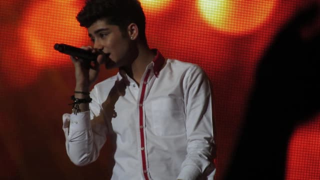 Zayn Malik cantando ao microfone durante show, foto de arquivo
