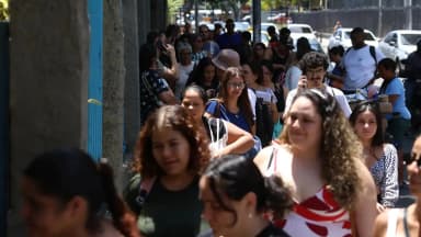 Candidatos caminham em fila para prova de concurso público em foto de arquivo ilustrativa