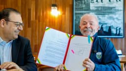 Presidente Luiz Inácio Lula da Silva exibe lei recém-sancionada ao lado de auxiliar durante cerimônia no Palácio do Planalto (foto de arquivo, ato de sanção de outra lei em junho de 2026)