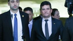 O senador Sergio Moro caminha ao lado de assessores em corredor de prédio público (foto de arquivo)