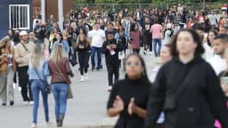 Multidão caminha em área de acesso a evento com grande público