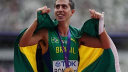 Caio Bonfim comemora com a bandeira do Brasil e a medalha após vitória em prova de atletismo