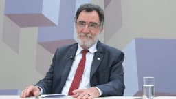 Patrus Ananias sentado em estúdio de TV da Câmara dos Deputados, gesticulando durante entrevista