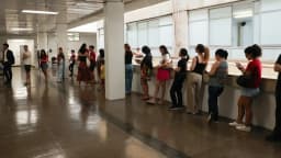 Fila de pessoas em corredor durante processo de consulta eleitoral