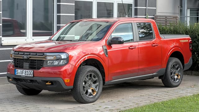 Ford Maverick vermelha, versão Tremor, estacionada em frente a uma casa