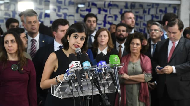 Tabata Amaral fala em coletiva de imprensa cercada de microfones