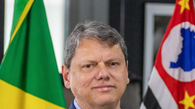 Retrato oficial do governador de São Paulo, Tarcísio de Freitas, com bandeiras do Brasil e de São Paulo ao fundo