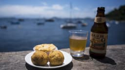 Petiscos e cerveja em mesa com vista para a Baía de Guanabara