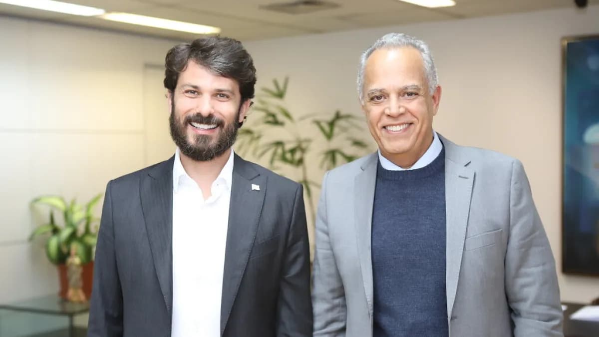 Marcelo Aro sorri ao lado do presidente do TCE-MG, Gilberto Diniz, em ambiente interno