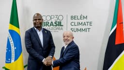 Daniel Chapo aperta a mão de Lula em reunião bilateral, com as bandeiras do Brasil e de Moçambique ao fundo