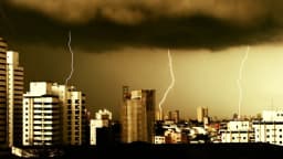Raios em tempestade sobre skyline de cidade brasileira
